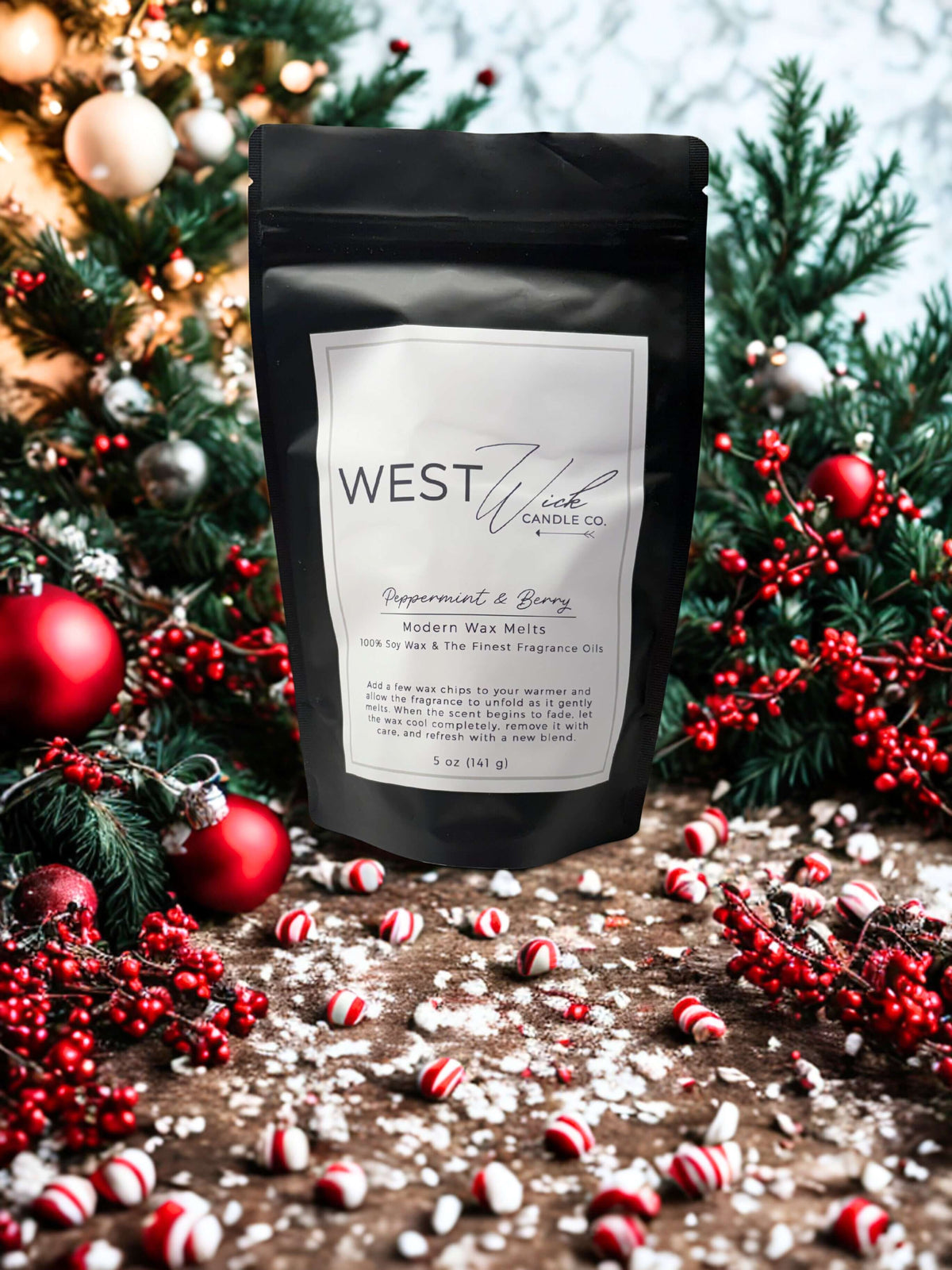 Peppermint &amp; Berry Wax Melts in a black pouch surrounded by holiday decorations and peppermint candies.