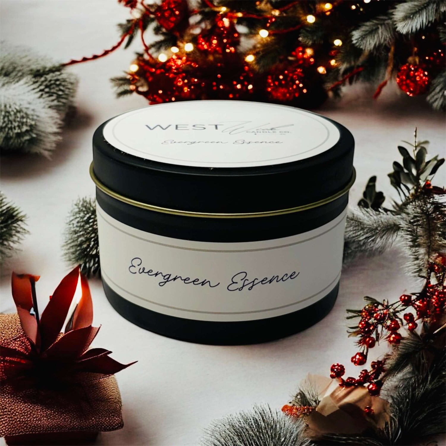 Evergreen Essence black luxe candle presented with holiday decor and festive elements in a cozy setting.