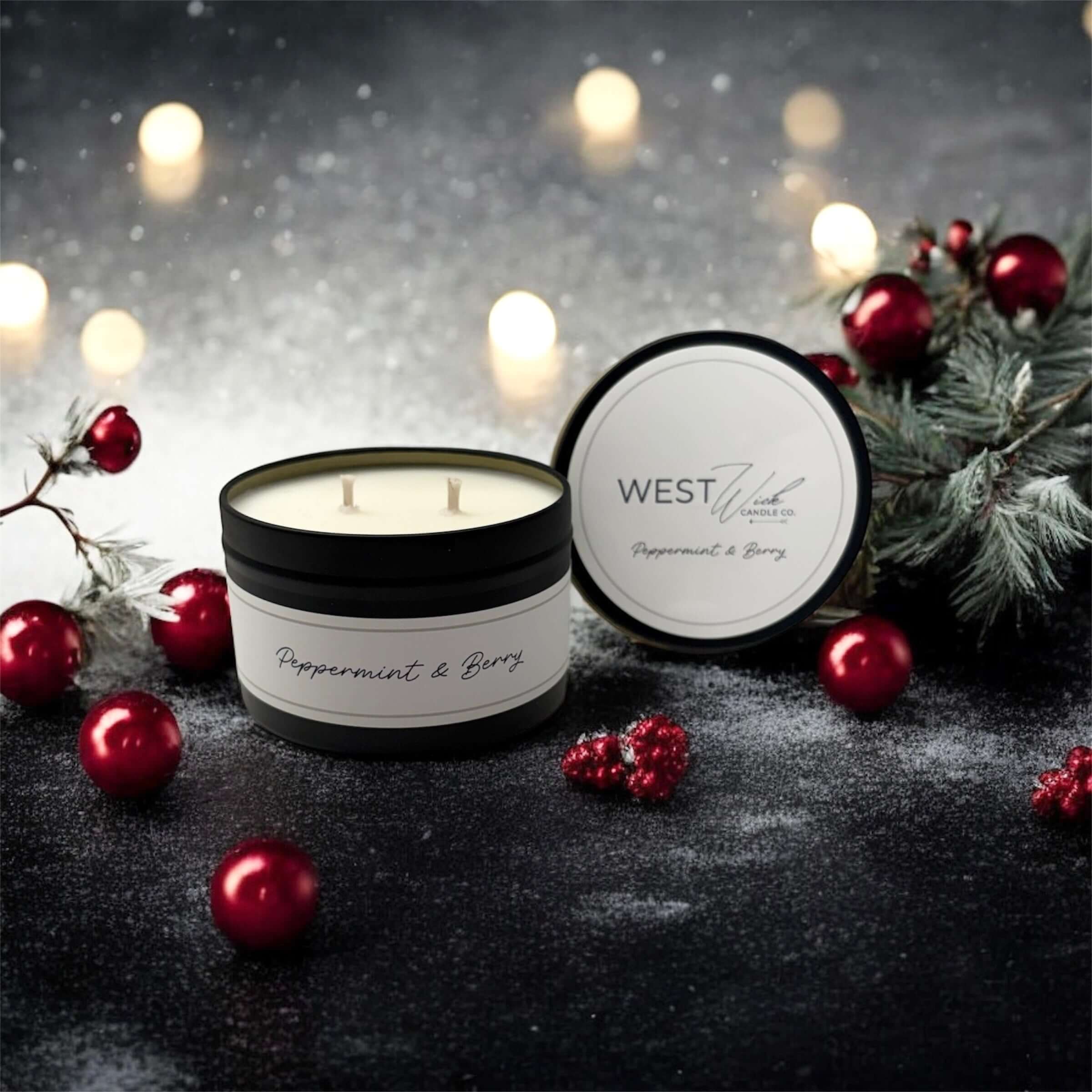 Peppermint &amp; Berry Black Luxe Candle surrounded by festive decorations and glowing lights.