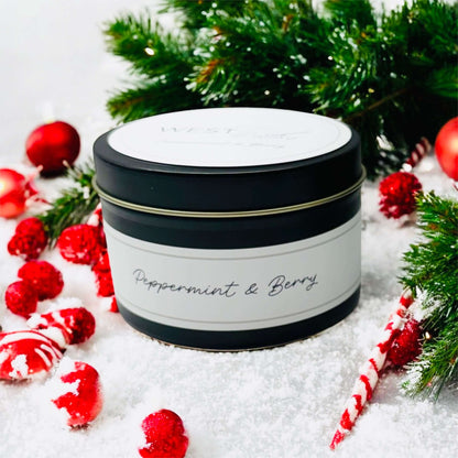 Peppermint &amp; Berry Black Luxe Candle surrounded by festive decorations and greenery.